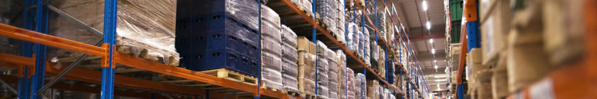 Interior of large distribution warehouse with shelves stacked with palettes and goods ready for the market.